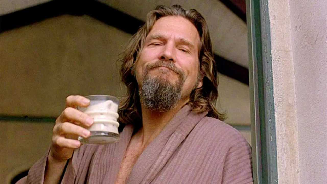 a man with a beard holding a White Russian cocktail