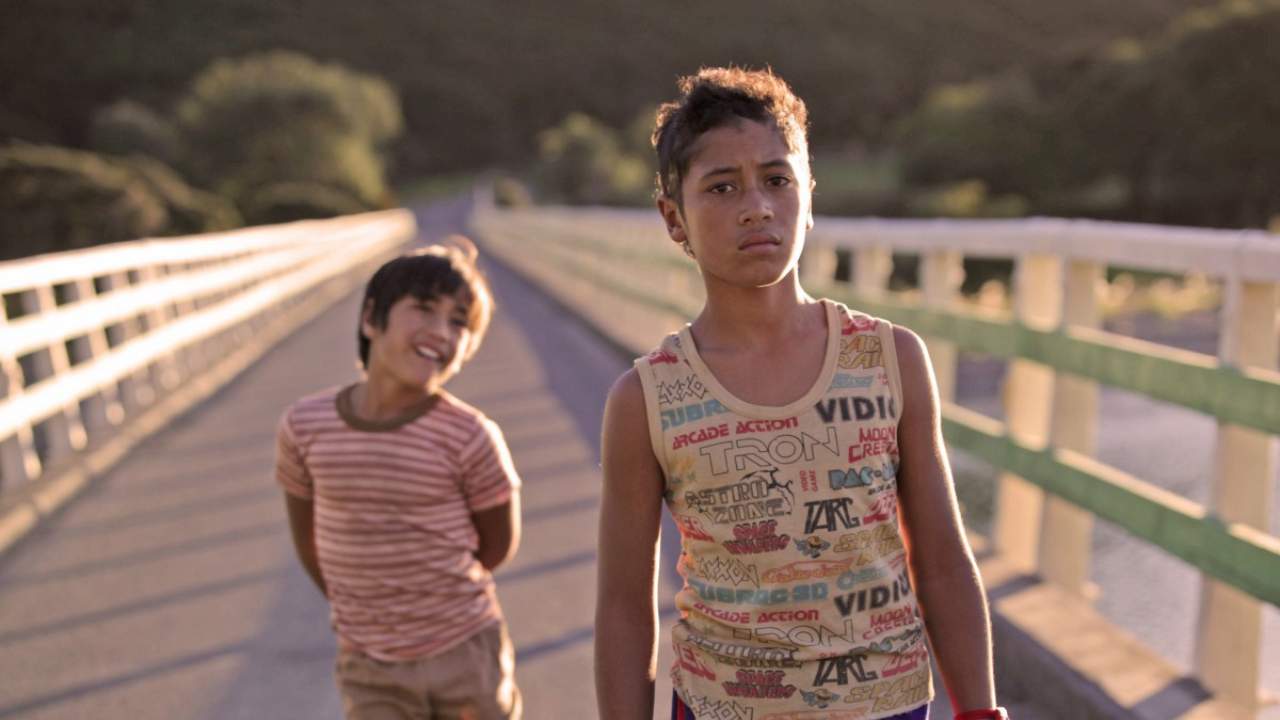 two boys walking across a bridge