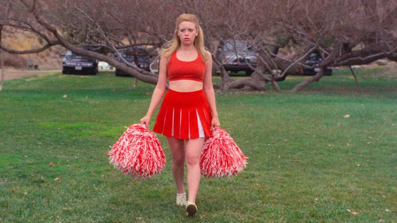 a cheerleader walking through a park
