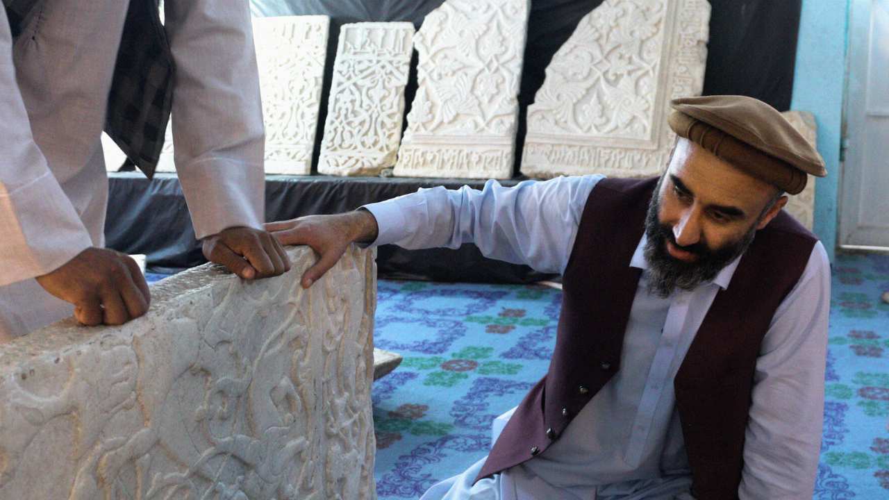 two men looking at an artifact