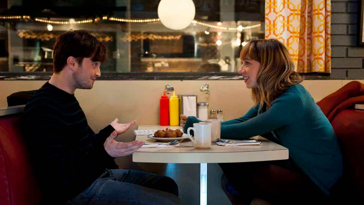 Daniel Radcliffe and a woman sitting together at a diner