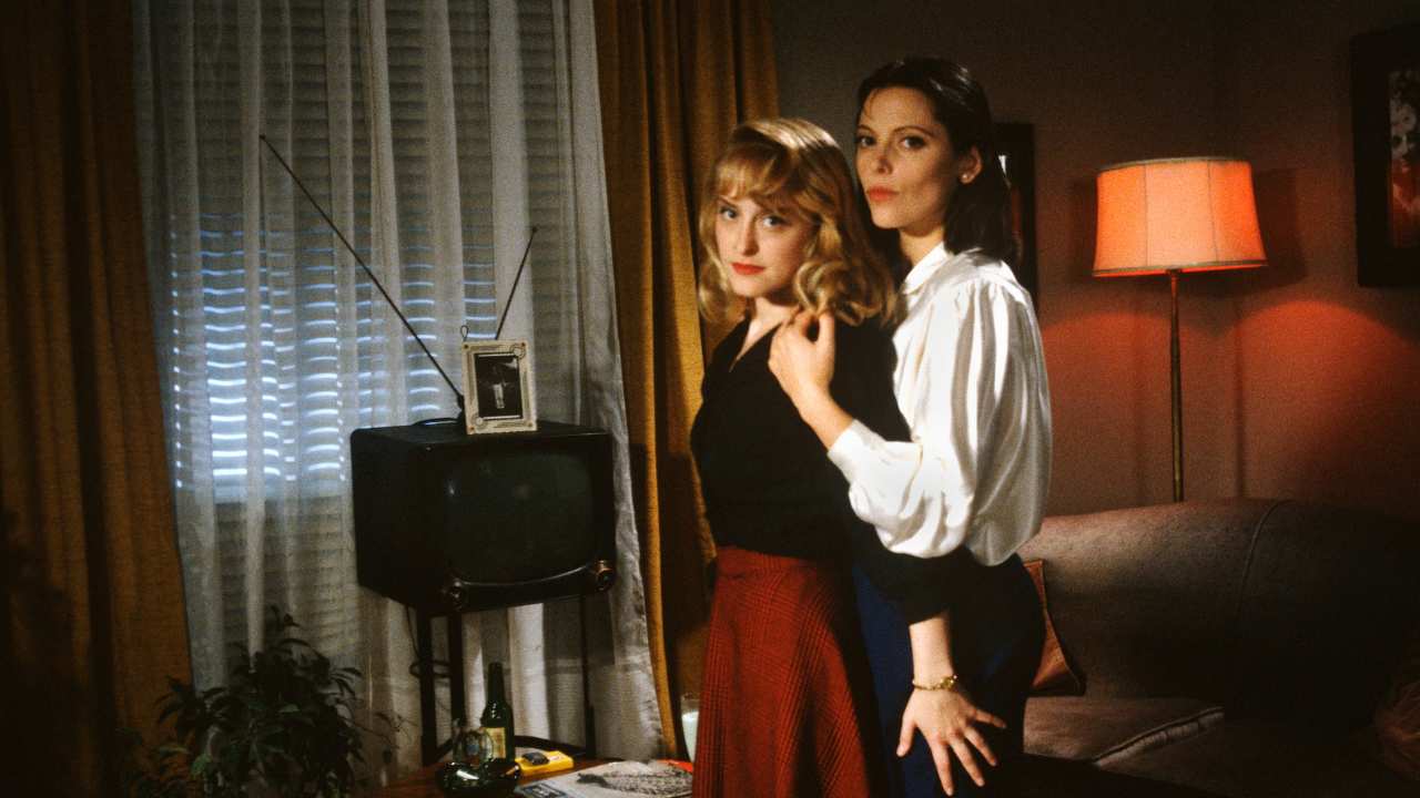 two women embracing each other in front of a tv