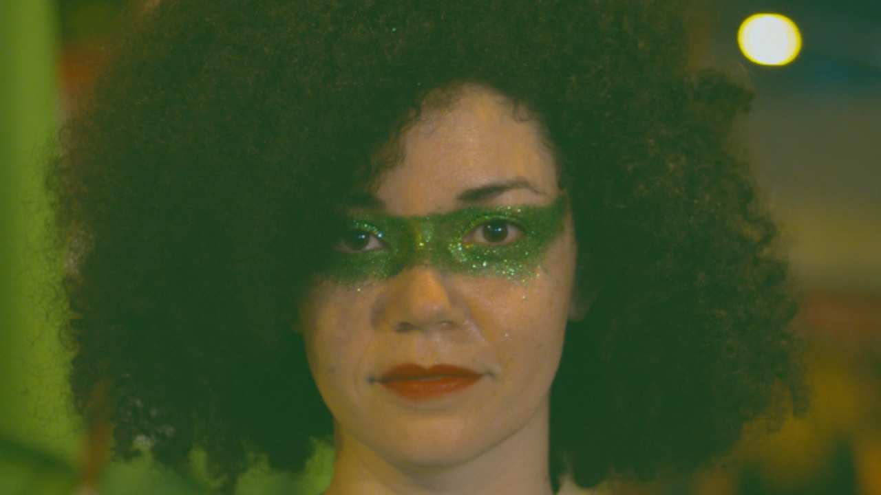 a person looking at the camera with green glitter makeup