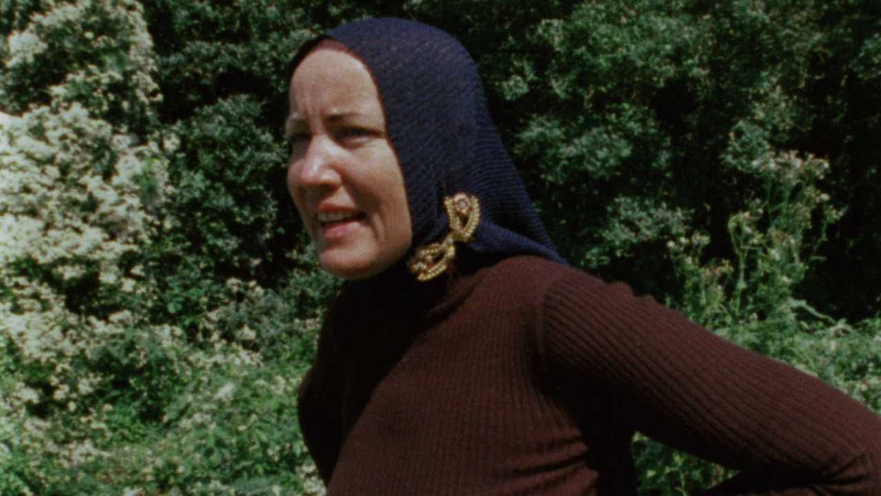 a woman with a knit headscarf looking to the left