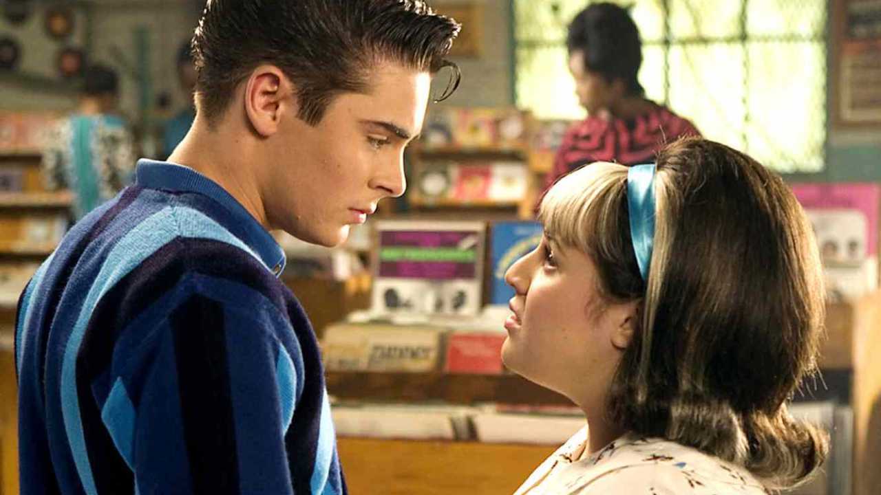 Zac Efron and Nikki Blonsky looking into each other's eyes in a record store