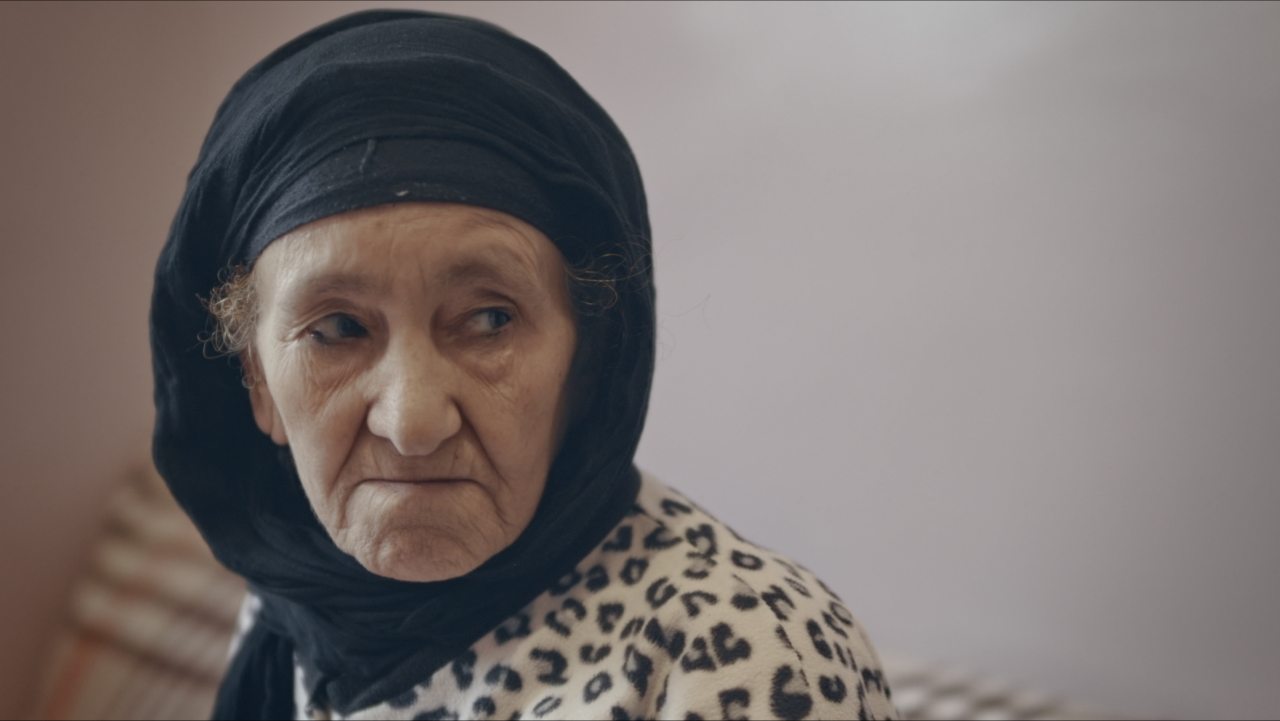 An elderly woman wearing a black head scarf