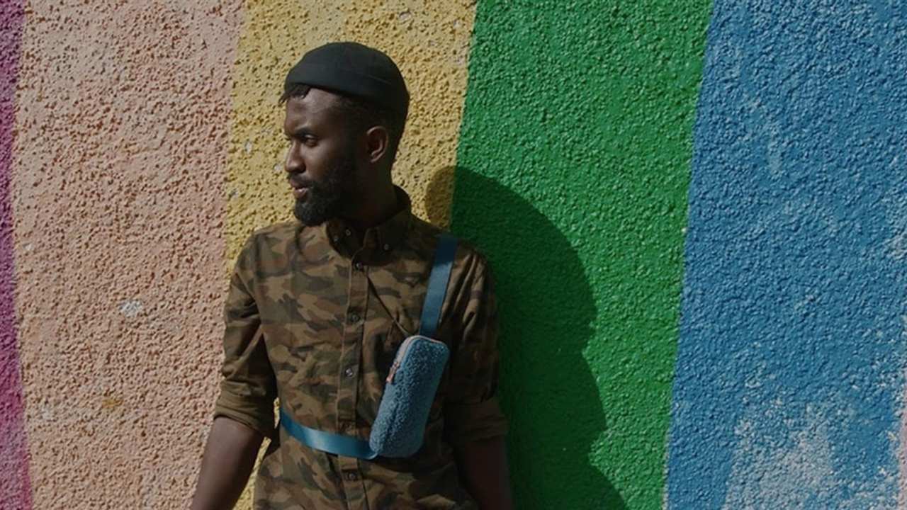 a person standing against a rainbow wall