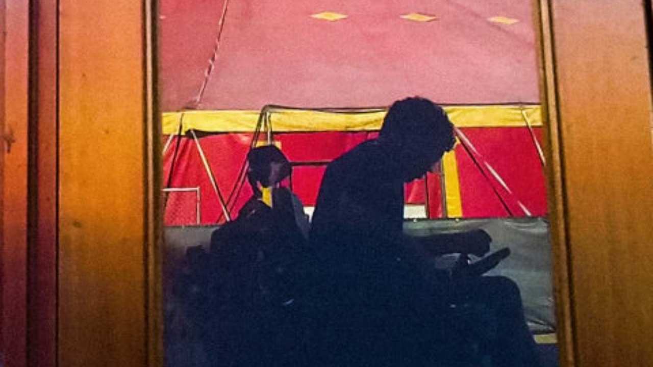 a person sitting in front of a circus tent