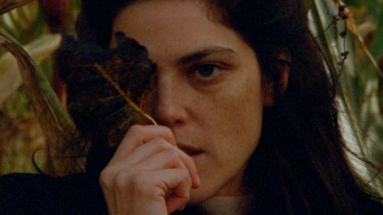 a woman with a leaf over one eye