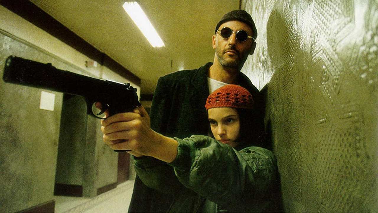 a man standing behind a woman holding a gun