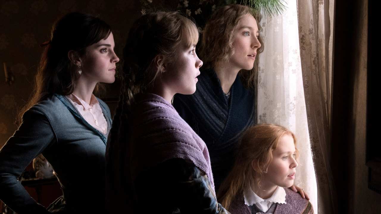 four young women looking out of a window together