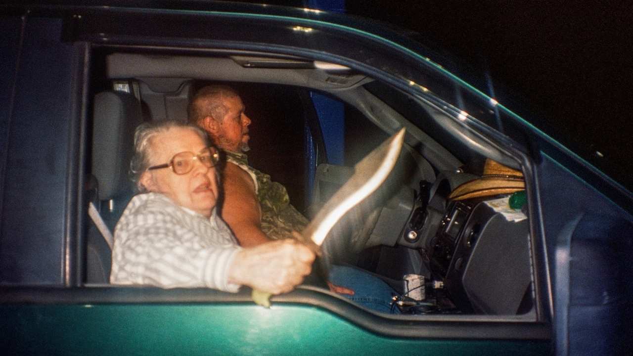 a woman with a knife next to a man in a car