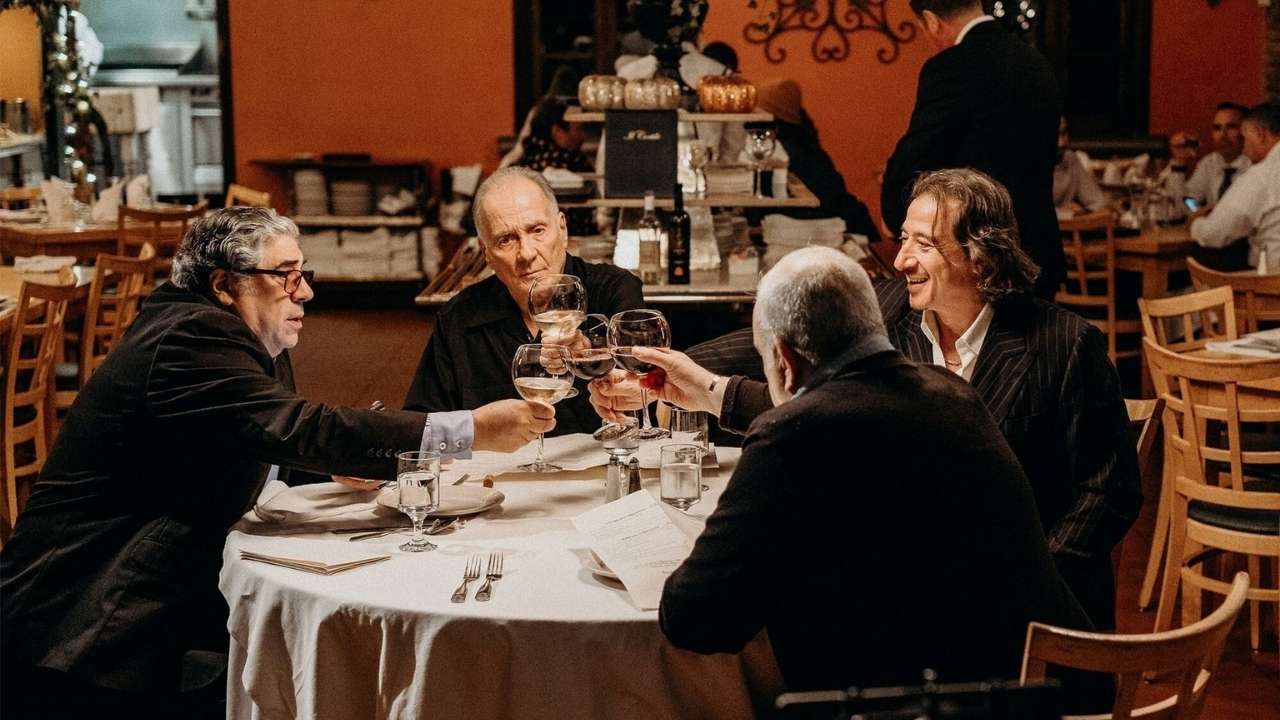 four men clinking wine glasses
