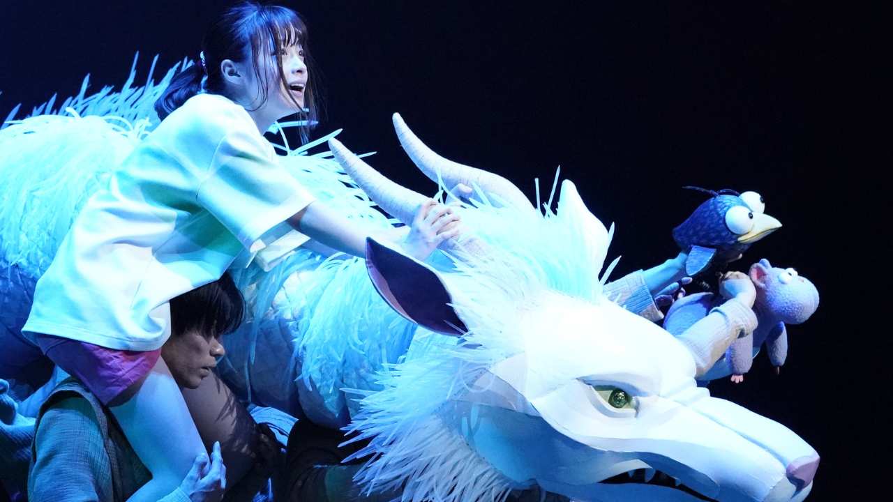 a young girl with a white dragon on stage