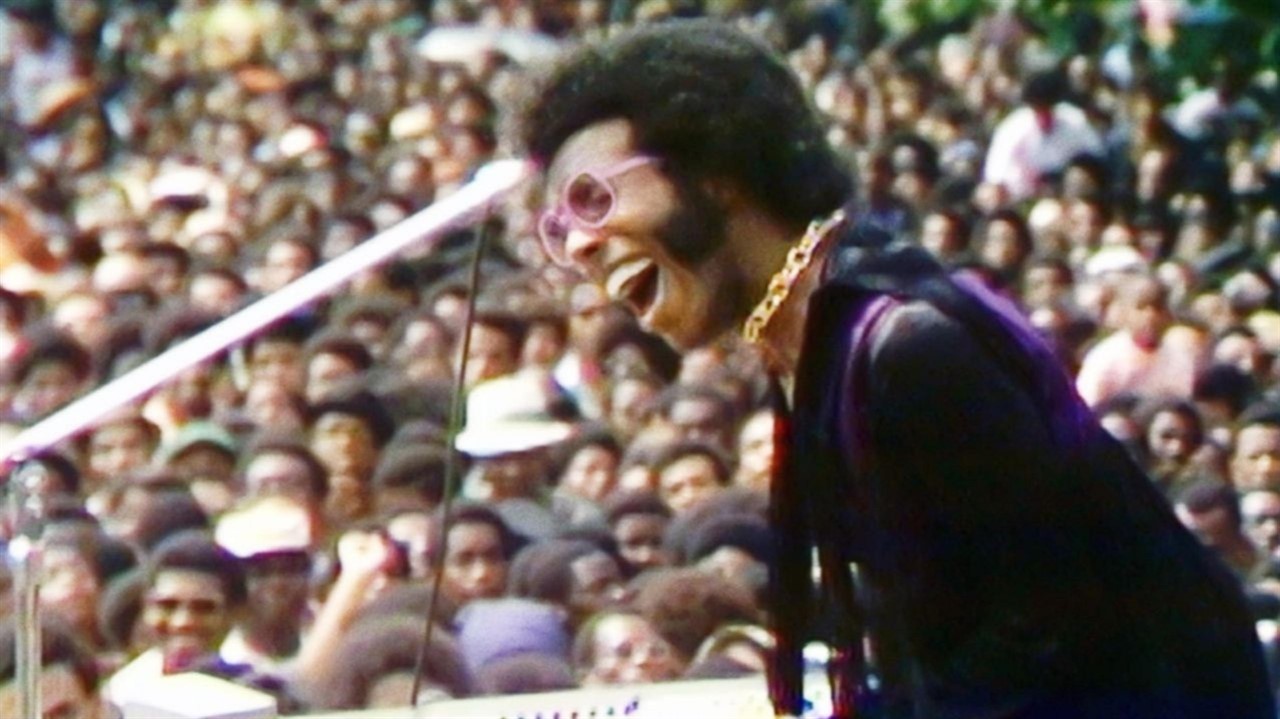 a man singing and playing keyboard on stage