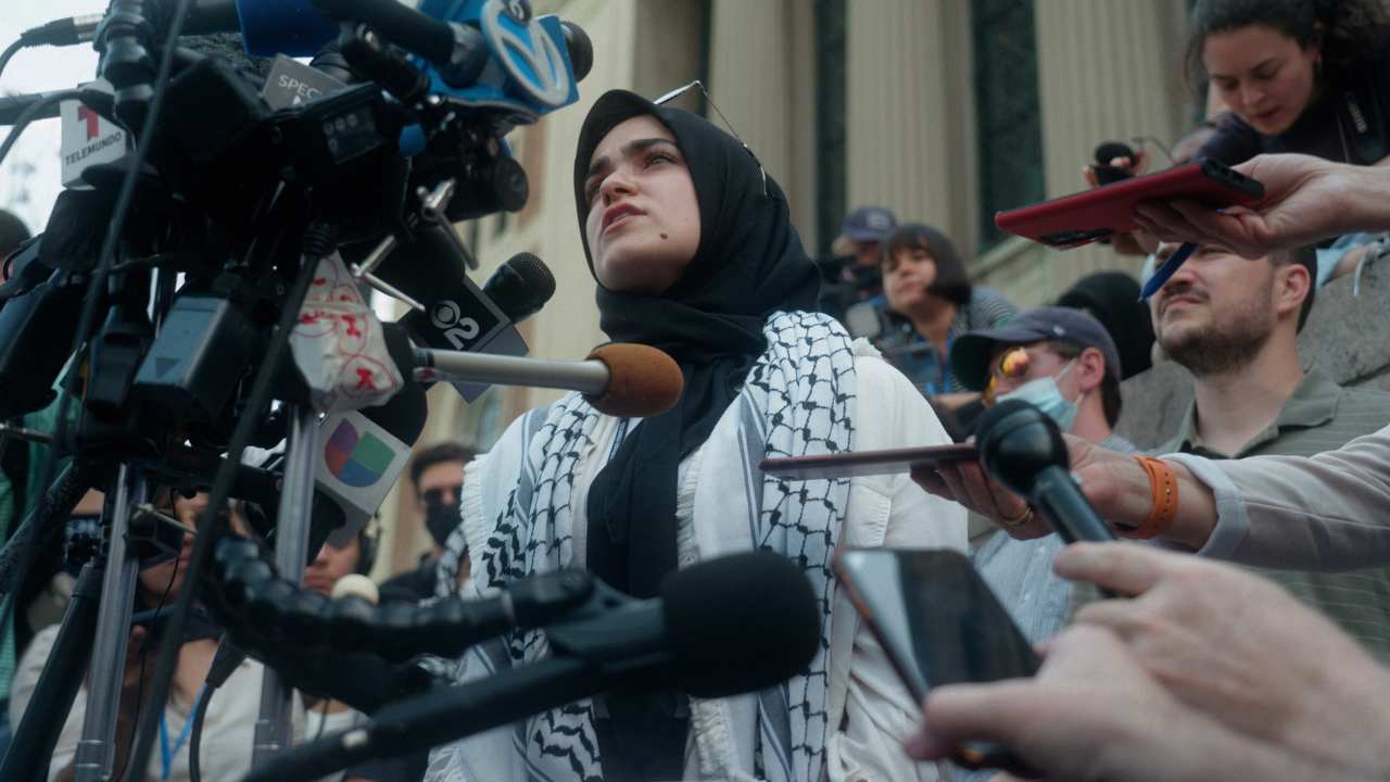 a woman speaking into multiple microphones