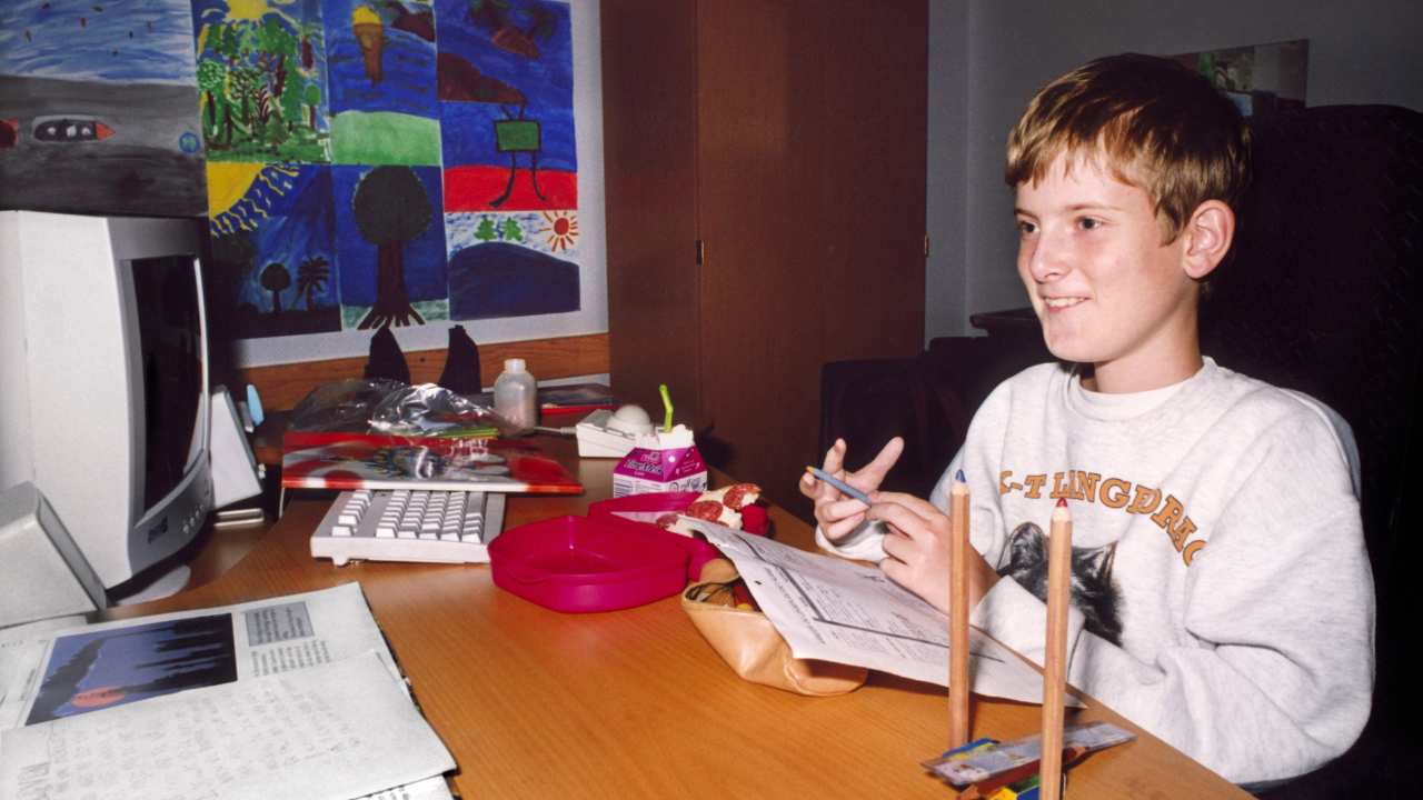 a young boy sitting in front of a computer