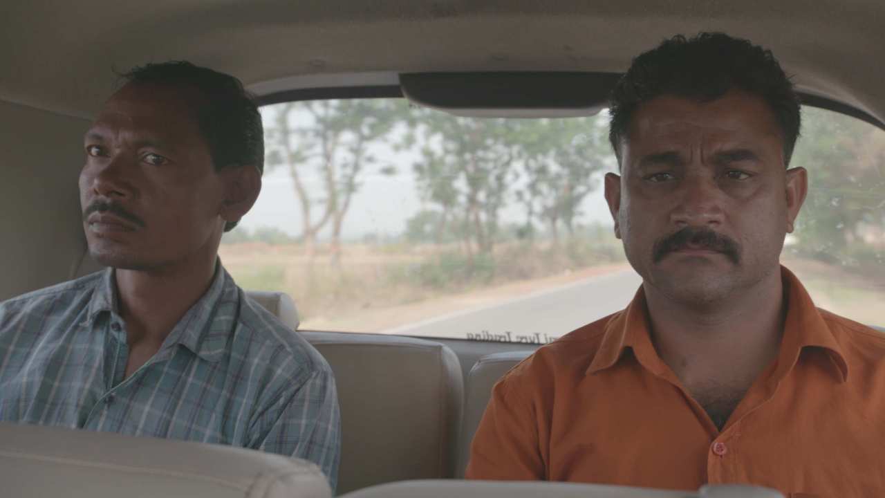 two men sitting together in a car