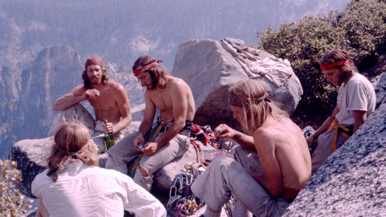 a group of men with long hair and headbands sitting together