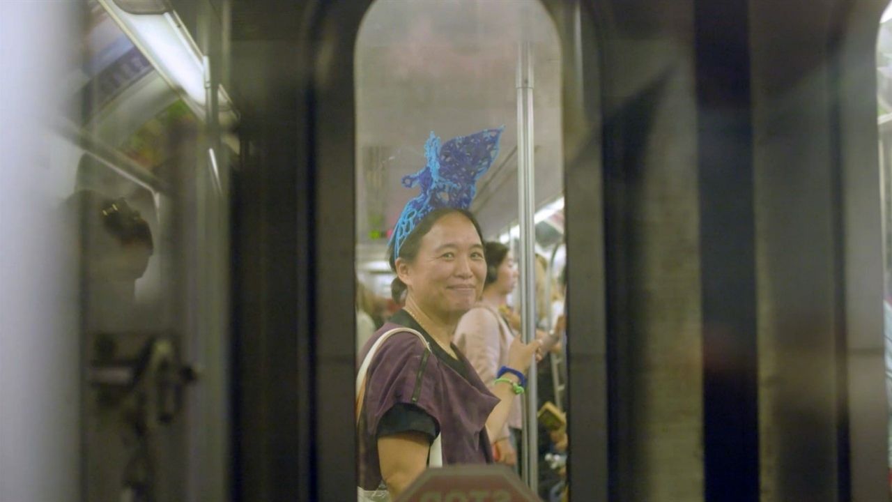 Woman on subway with bright blue hair thing