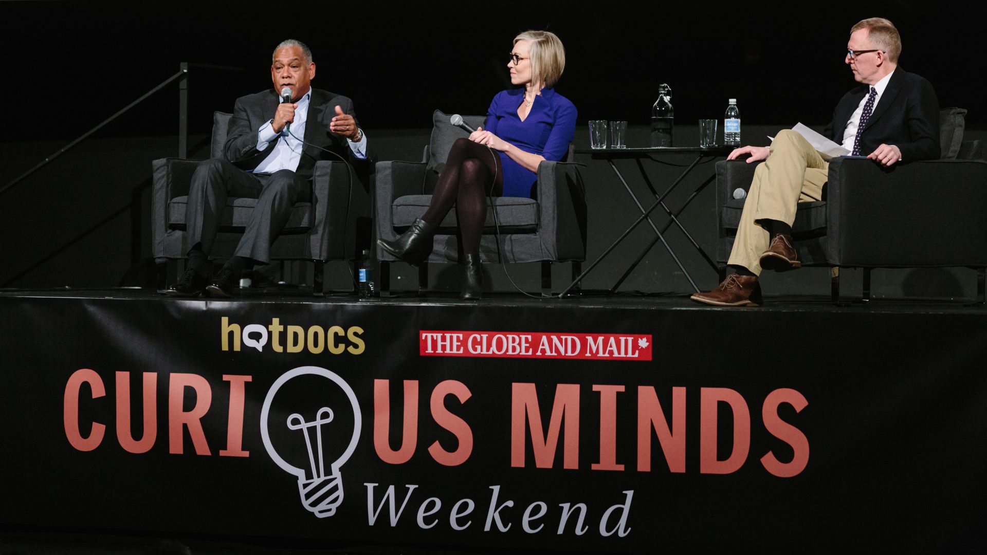 Three participants on-stage during Curious Minds Speaker Series